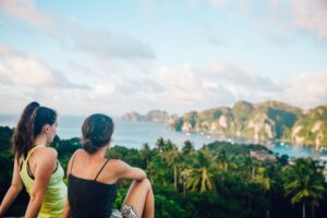 two women overlooking water on cliff