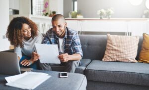 Young couple on couch looking at paperwork