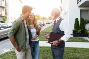 two people talking to landlord outside apartment