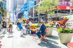 people sitting in chairs near times square in nyc
