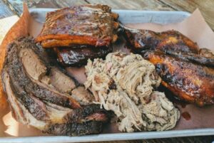 bbq tray filled with ribs, pulled pork, and brisket