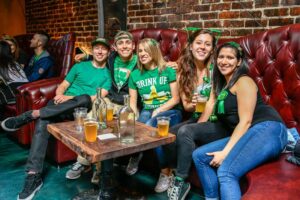 people sitting on leather couch drinking beers
