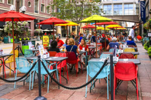 people sitting in brightlycolored chairs outside of restaurant in minneapolis, minnesota