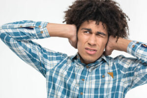 man holding hands over ears because of loud neighbor