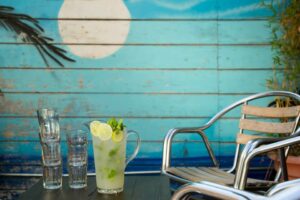 margarita pitcher on table in front of with painted blue background