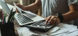 person typing on a calculator