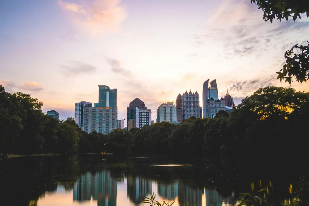 Atlanta skyline at sundown with trees and a lake, representing the city served by the top 6 Atlanta moving companies