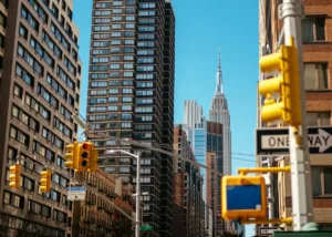 Street-level view of New York City with the Empire State Building, representing the dense neighborhoods renters compare for cheaper housing
