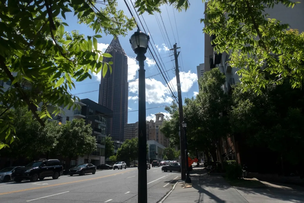 Tree-lined Atlanta street with the Midtown skyline in the background, reflecting the type of urban environment near surrounding cities