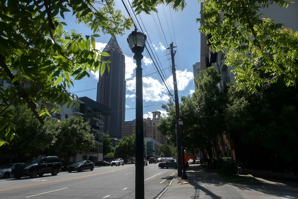 Tree-lined Atlanta street with the Midtown skyline in the background, reflecting the type of urban environment near surrounding cities