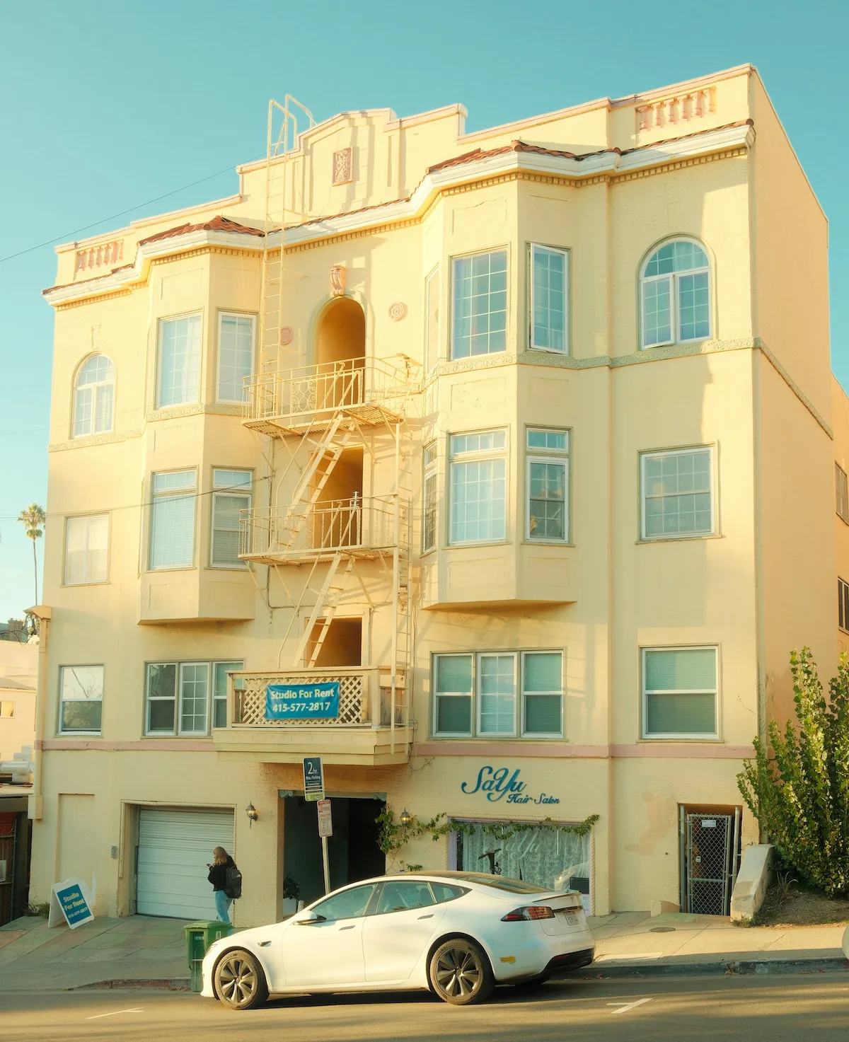 A multi-story apartment building with a Studio For Rent sign on the balcony in San Francisco, where the median one-bedroom rent is $3,670 per month