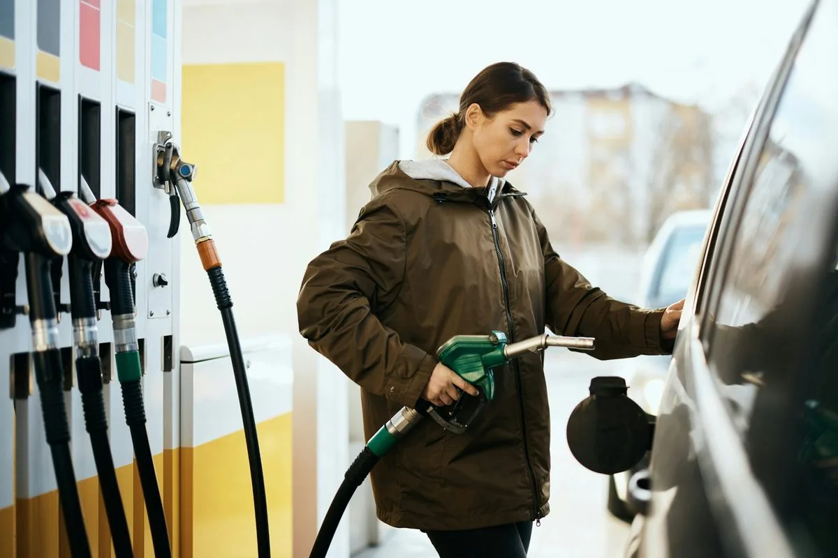 woman filling her car tank at the gas station